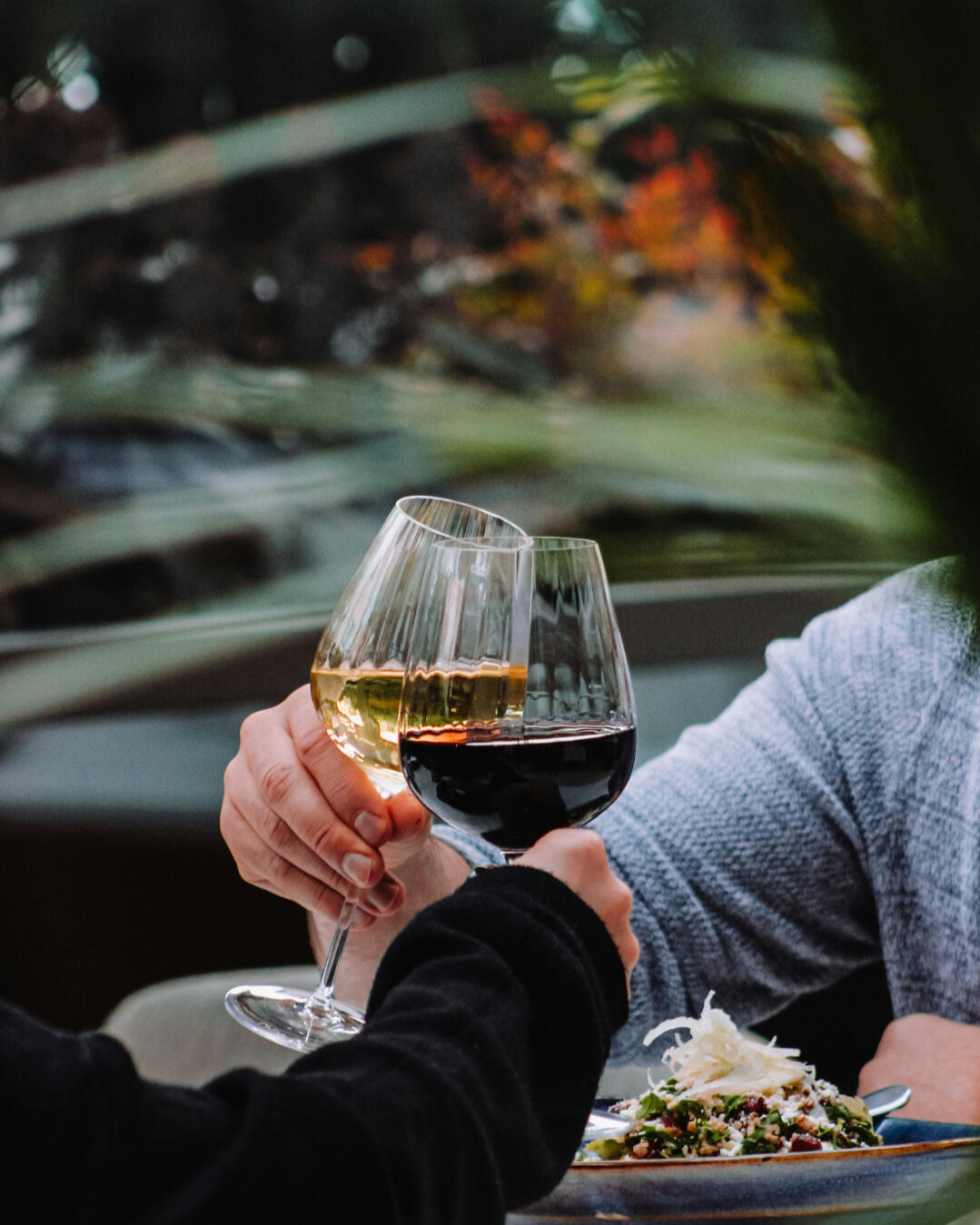 Skåla i vin hemma – dejttips från Dejtkortet Två händer som skålar med vin, en enkel och romantisk hemmadejt från Dejtkortet.