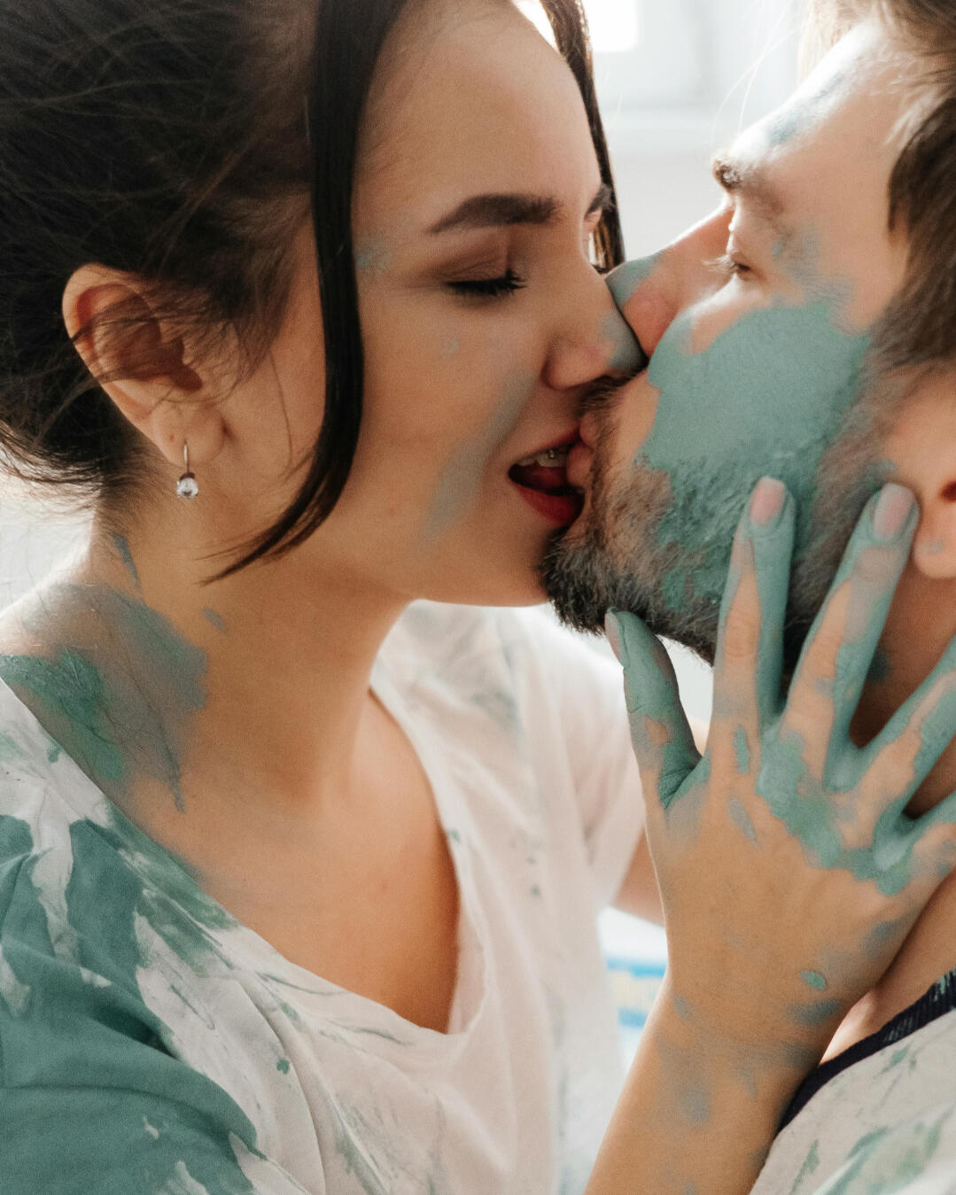 Lekfull dejt hemma – Dejtkortet Par med färg på kroppen och ansiktet som kysser varandra, lekfull dejtinspiration från Dejtkortet.